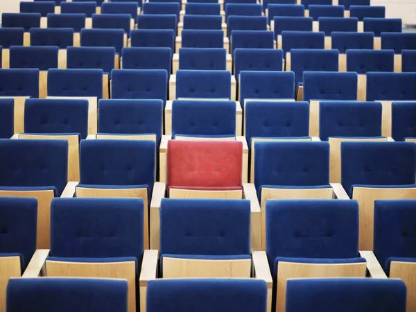 Rode stoel in groep van blauw — Stockfoto