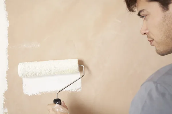 Man painting wall with paint roller — Stock Photo, Image