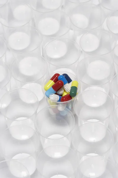 Pillole della capsula in tazza di plastica — Foto Stock