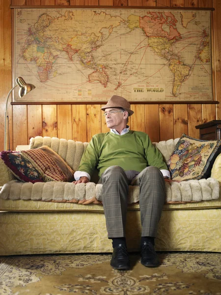 Senior man sitting on sofa — Stock Photo, Image