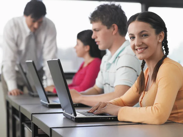 Estudiantes usando computadoras portátiles en el aula — Foto de Stock