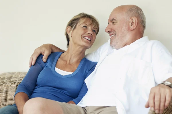 Middle Aged Couple sitting on wicker chair — Stock Photo, Image