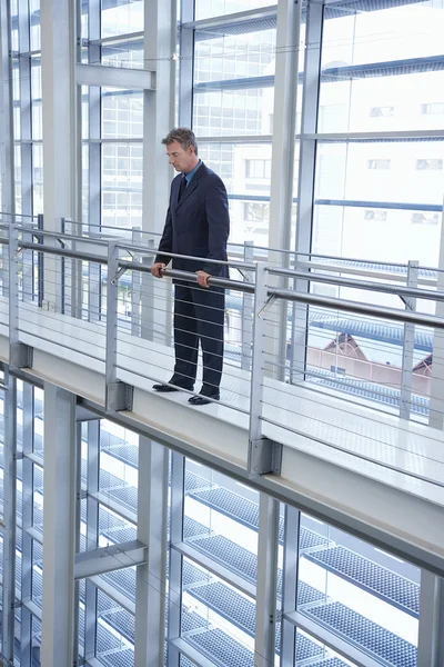 Homme d'affaires regardant par-dessus la rampe — Photo
