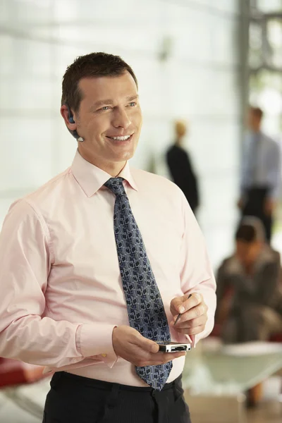 Businessman Using Headset and PDA — Stock Photo, Image