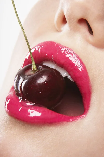 Žena kousání cherry — Stock fotografie
