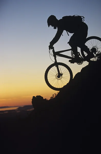 Mountain biker riding down slope — Stock Photo, Image