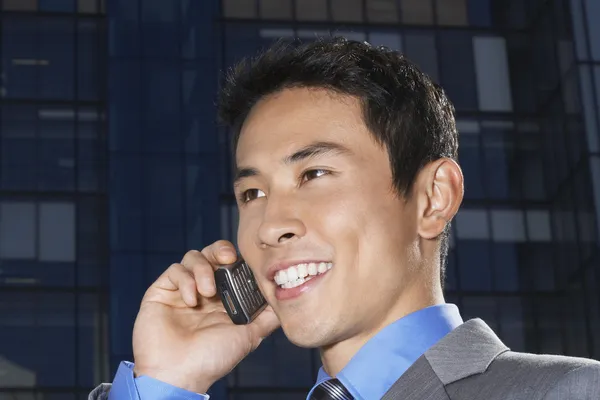 Empresário sorrindo usando telefone celular — Fotografia de Stock