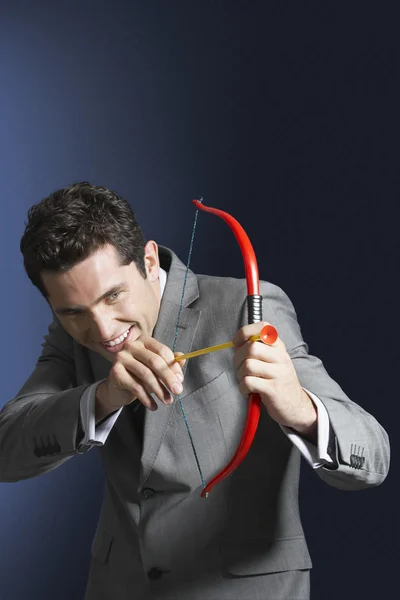 Hombre apuntando arco de juguete y flecha — Foto de Stock