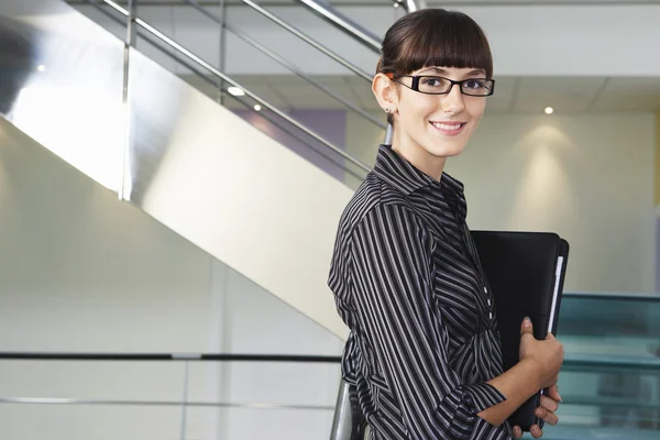 Businesswoman standing in office corridor — Stock Photo, Image