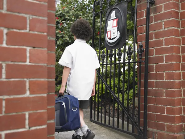 Colegial de primaria caminando por la puerta — Foto de Stock