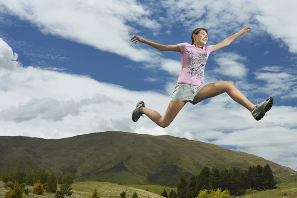 Woman leaping in hills — Stock Photo, Image