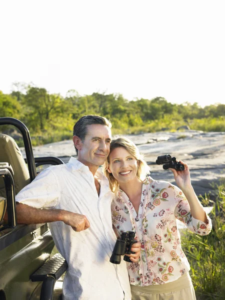 Couple standing by jeep — Stock Photo, Image