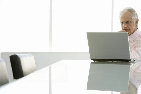 Businessman using laptop at conference table — Stock Photo, Image