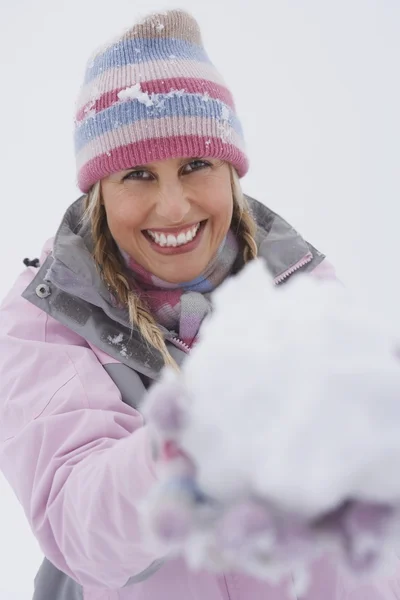 Kvinna som håller snöboll — Stockfoto