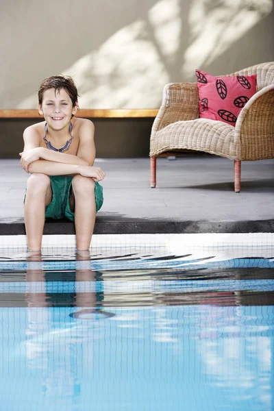 Junge sitzt Pool — Stockfoto