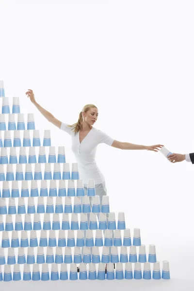 Man handing woman plastic cup for stacked pyramid — Stock Photo, Image