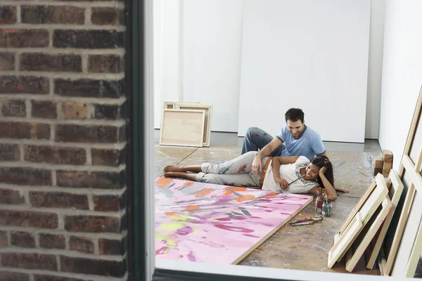 Пара розслабляється на підлозі студії — стокове фото