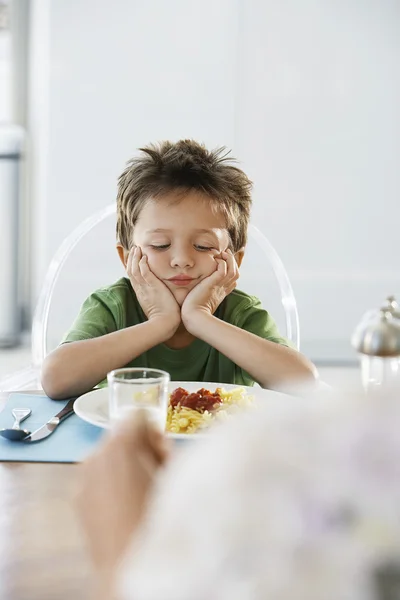 Uttråkad pojke med frukost måltid — Stockfoto