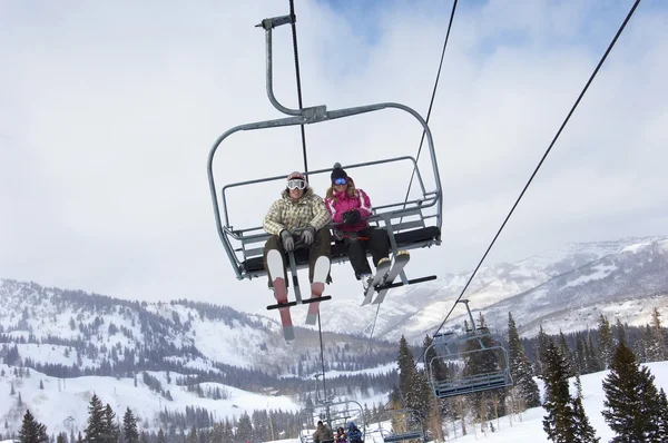 Par i skies sitter på ski lift — Stockfoto