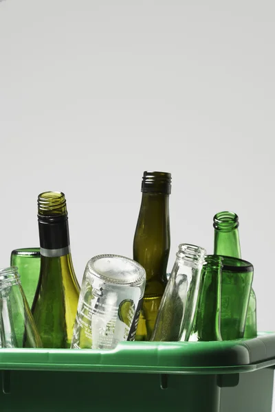 Empty bottles in green container — Stock Photo, Image