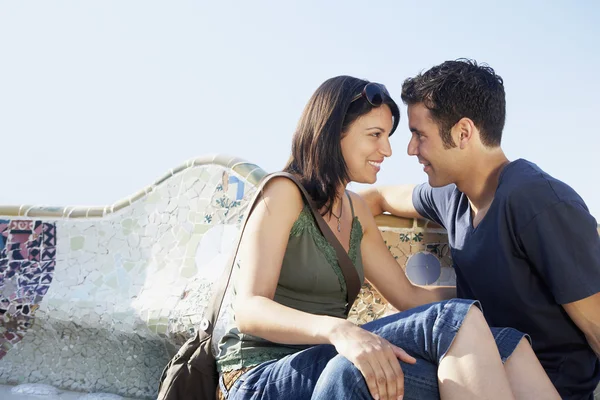 Paret sitter på sten bänk — Stockfoto