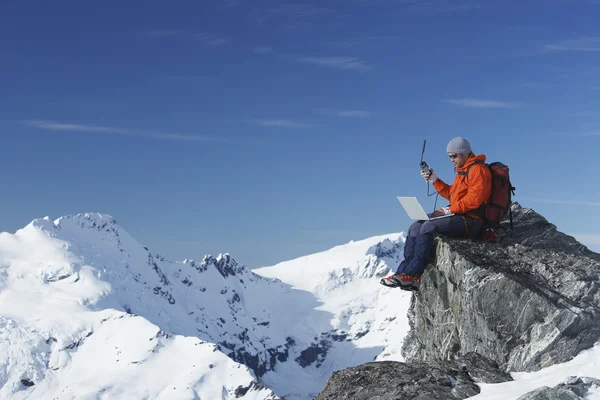 Scalatore di montagna con computer portatile — Foto Stock