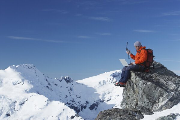Mountain climber using laptop