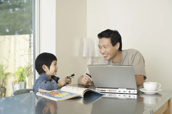 Pai e filho no laptop da cozinha — Fotografia de Stock