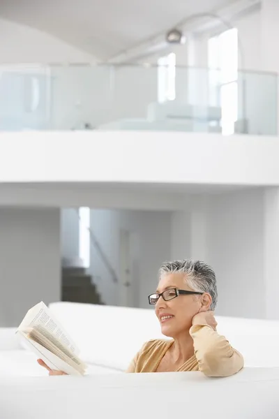 Frau liest auf Sofa — Stockfoto