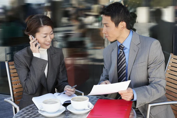 Businesspeople reviewing documents at cafe — Stock Photo, Image