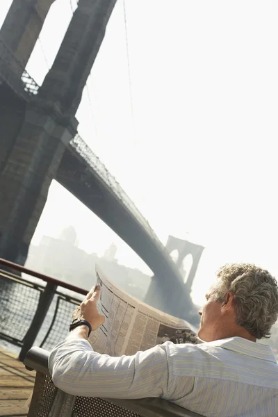 Man med tidningen av Brooklyn Bridge — Stockfoto