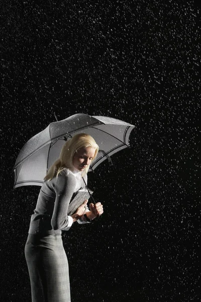 Affärskvinna hunching ner under paraply — Stockfoto