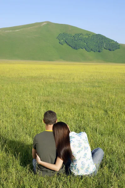 Couple sitting in field — Stock Photo, Image