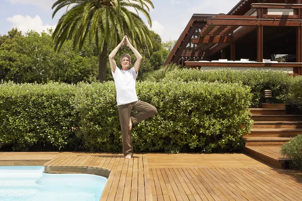 Man by swimming pool doing tai chi — Stock Photo, Image