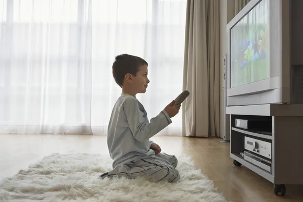 Jongen op verdieping televisie kijken — Stockfoto