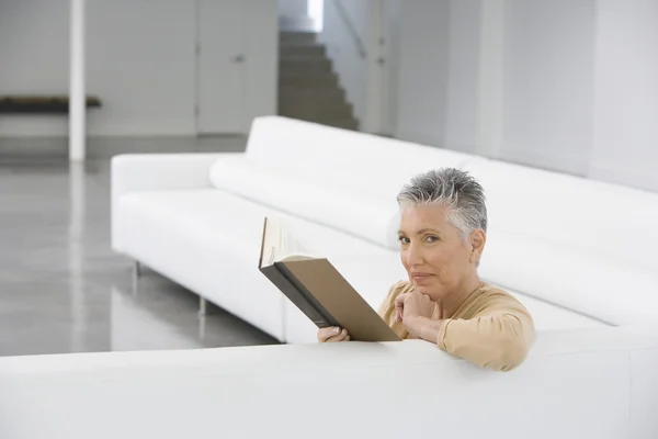 Улыбающаяся пожилая женщина с книгой — стоковое фото