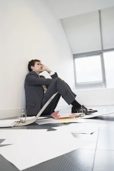Стрессовый бизнесмен сидит на полу — стоковое фото