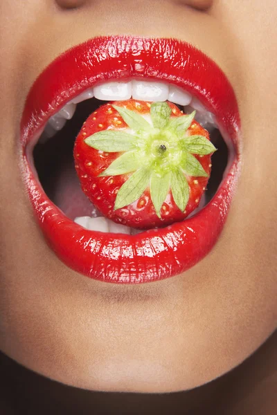 Woman's mouth with strawberry Royalty Free Stock Images