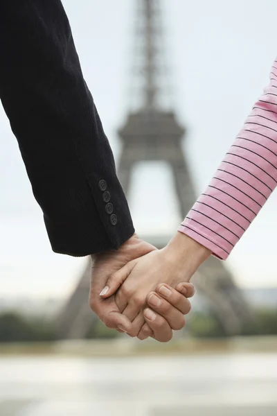 Holding hands in front of Eiffel Tower — Stock Photo, Image