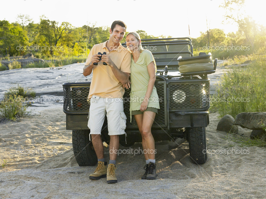 Couple near jeep with binoculars