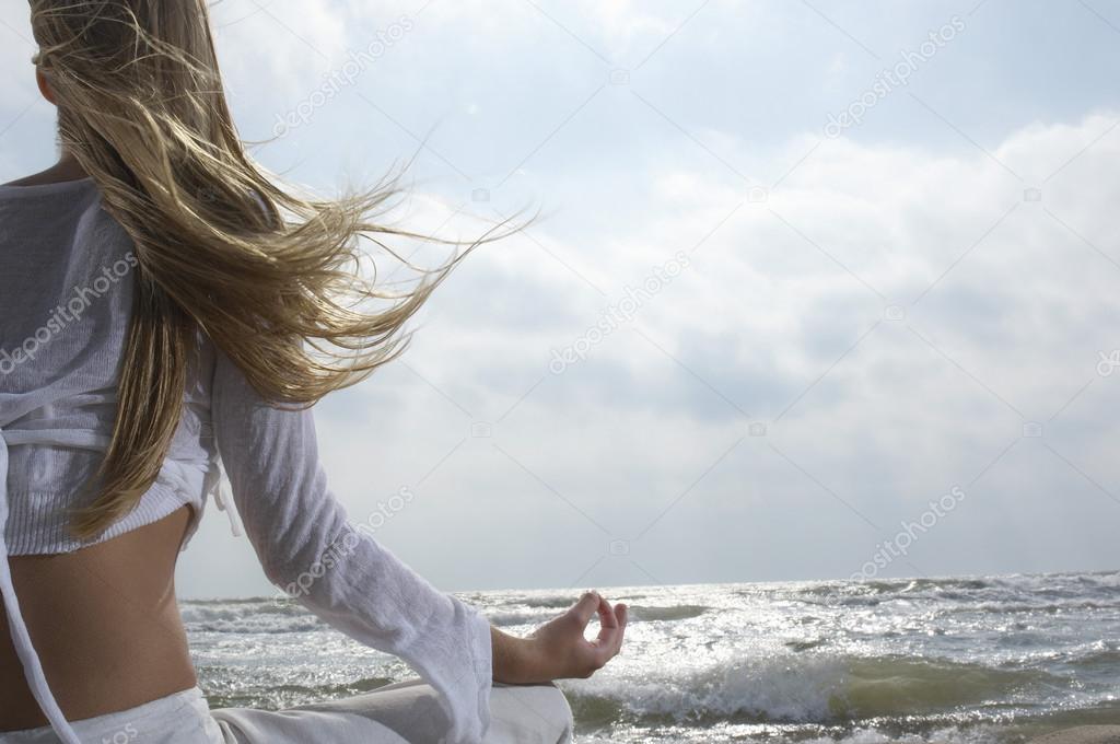 Woman Meditating on the Beach