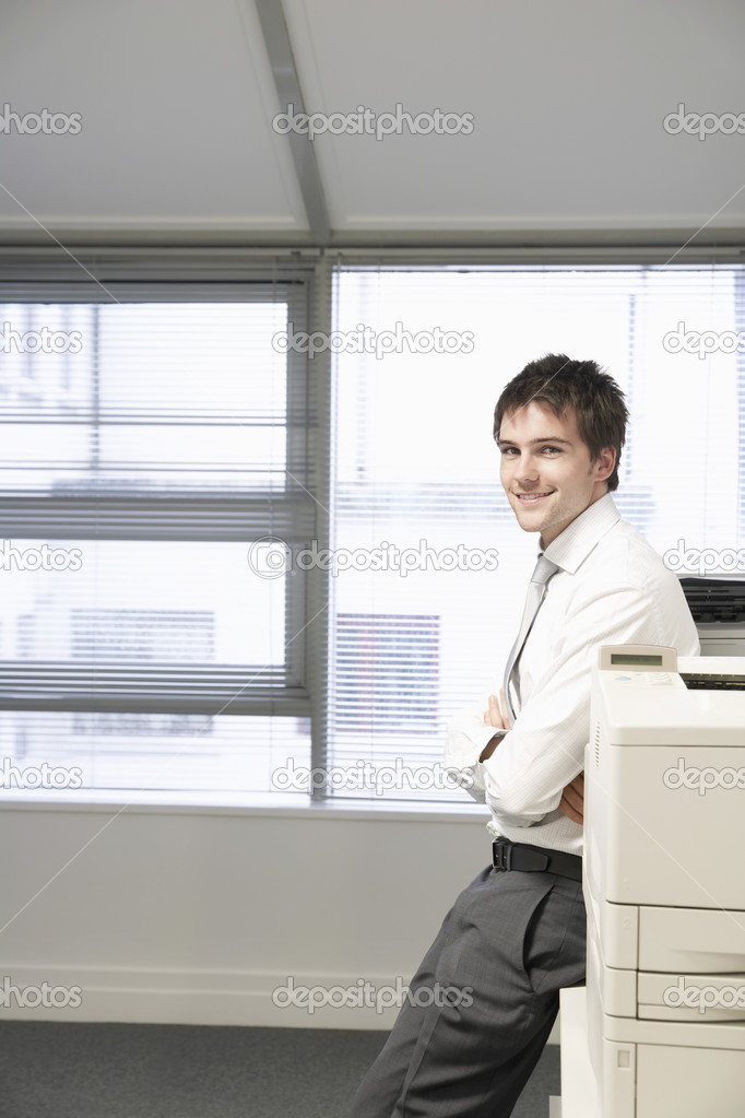 Businessman leaning against photocopier