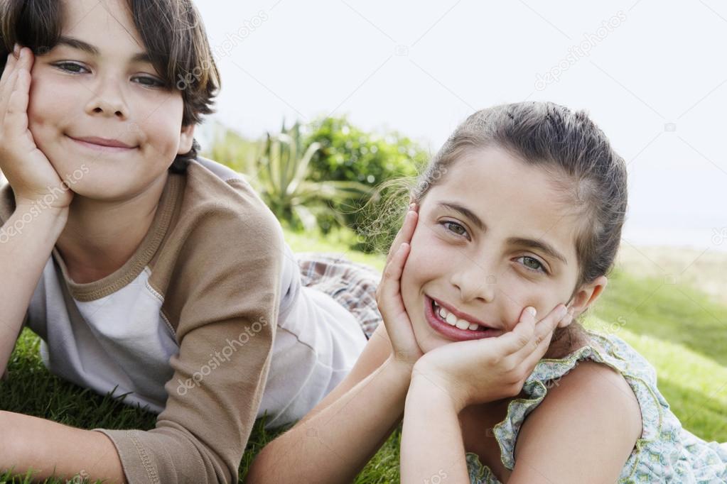 Boy and girl reclining hands on chin