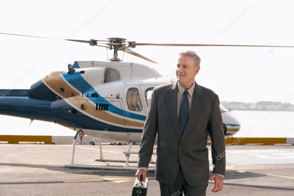 Businessman arriving on helicopter pad
