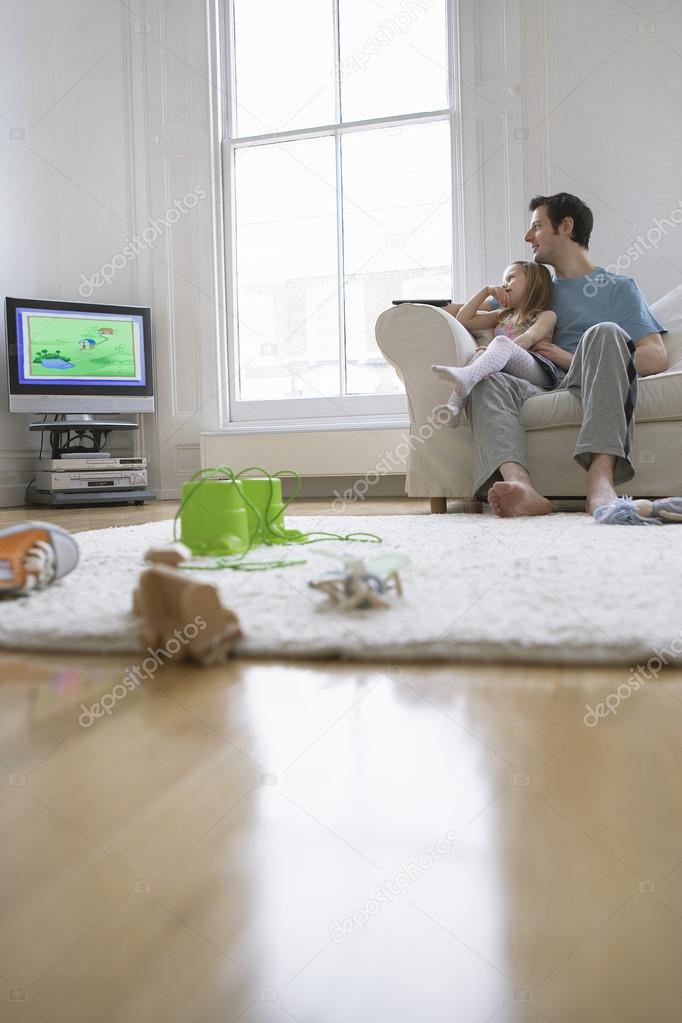 Father and daughter watching tv set