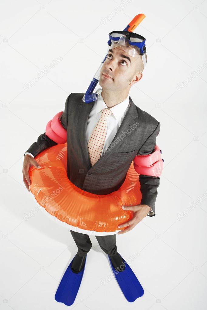 Businessman in flippers, life ring and goggles