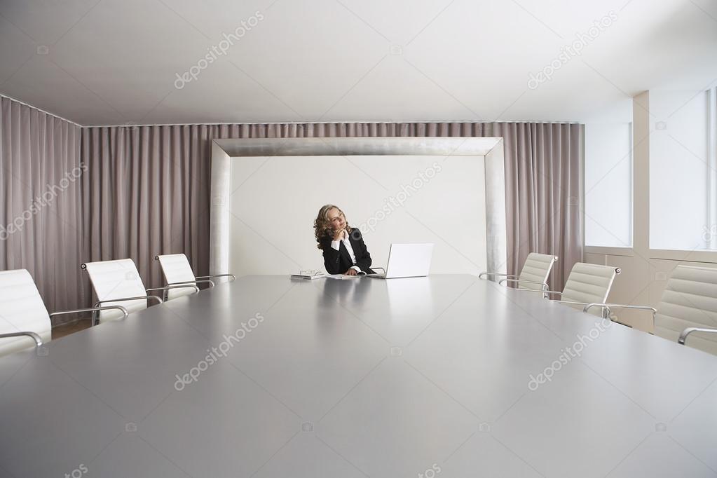 Executive Sitting in Boardroom using Laptop