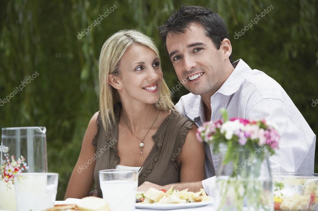 Couple dining at table in garden