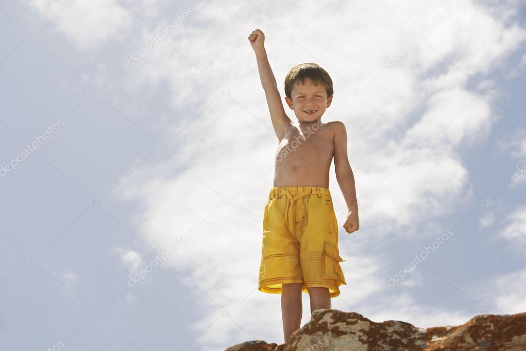 Boy standing on rock on beach