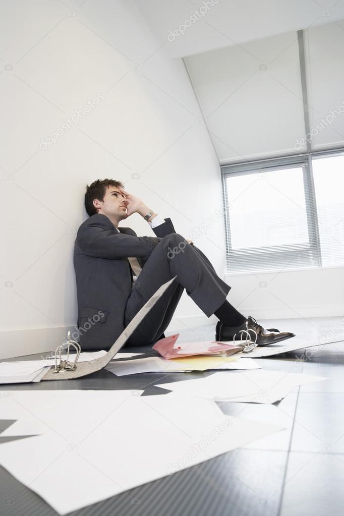 Stressed businessman sitting on floor